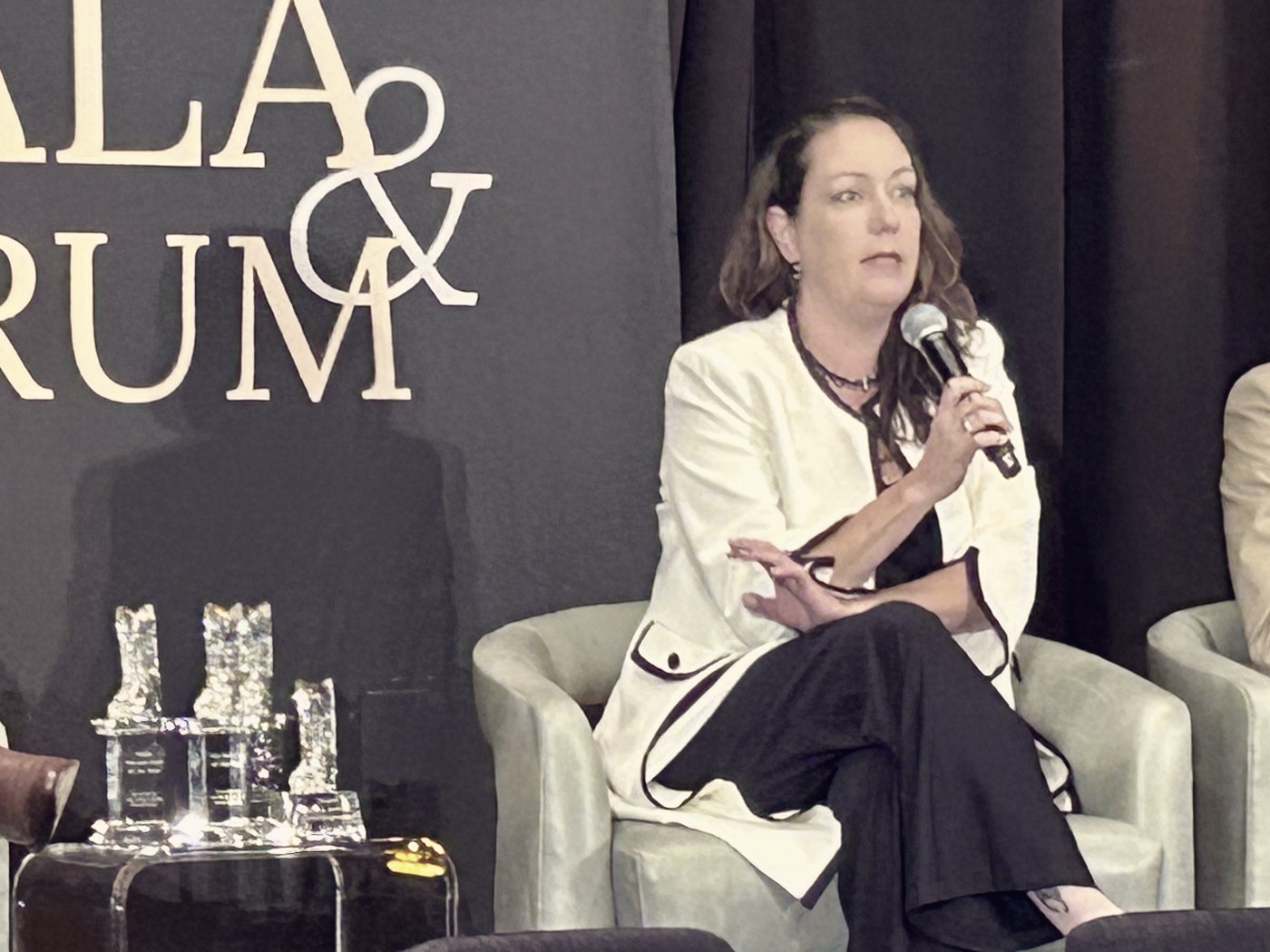 Meagan Crawford on a panel, holding a microphone mid-answer.